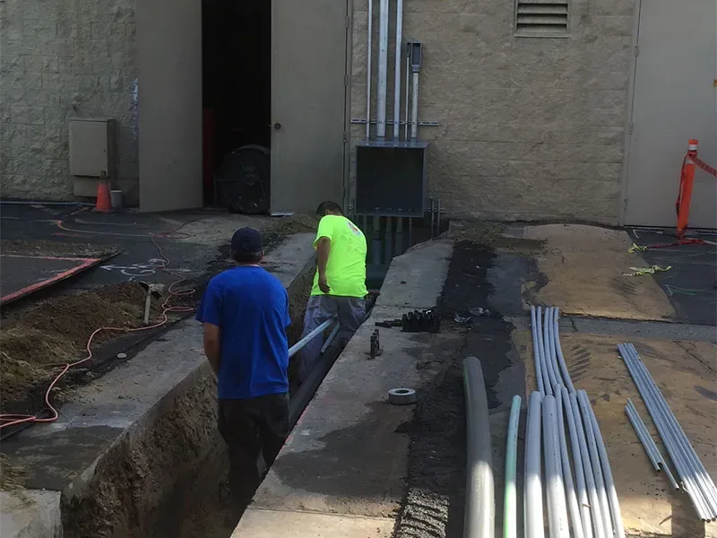 Electricians working in an outdoor trench